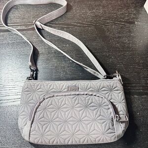 Lug Flyer convertible crossbody bag in a grey color with a starburst Pattern